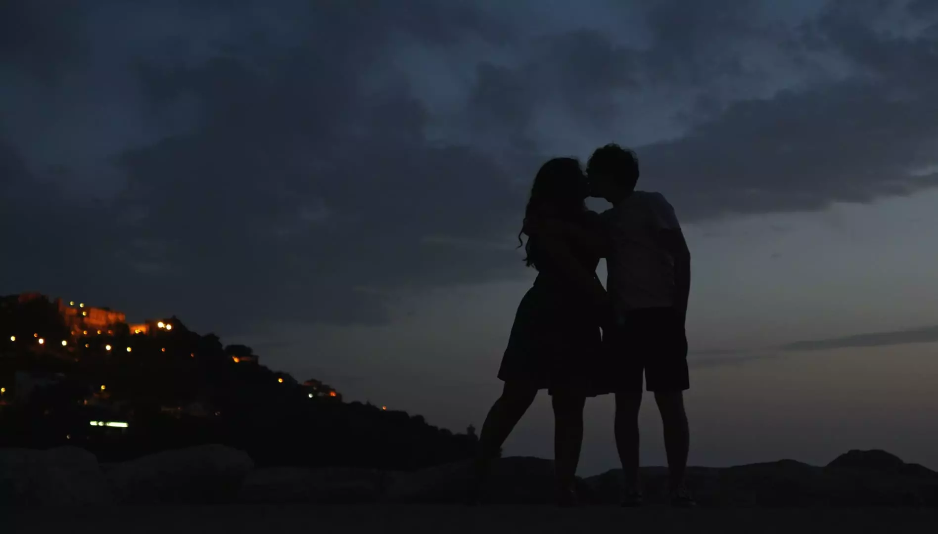 Two silhouettes kiss each other